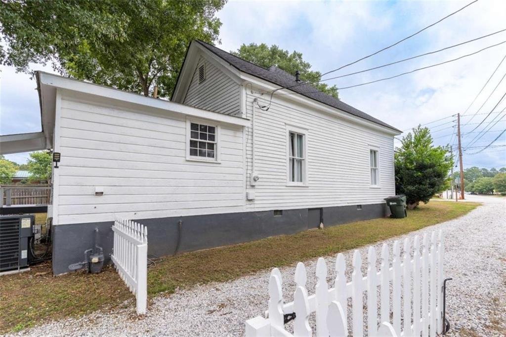 2173 Anderson Avenue Northeast Covington, GA 30014 - Photo 41 of 49 a view of a white house with a small yard and wooden fence