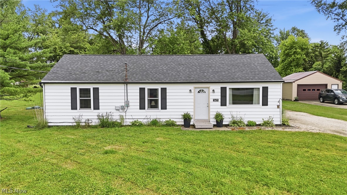 White siding exterior with black window shutters and a dark shingle roof