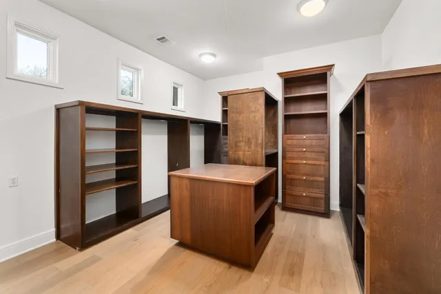 an empty room with a window and a fan