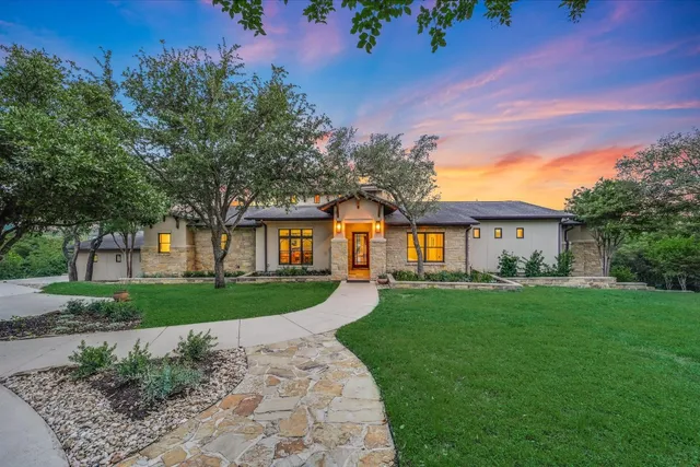 a front view of a house with a yard and trees