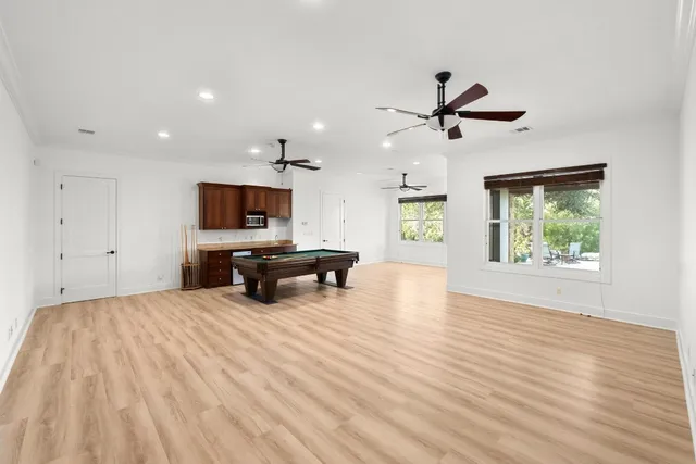 a room with wooden floor and ceiling fan