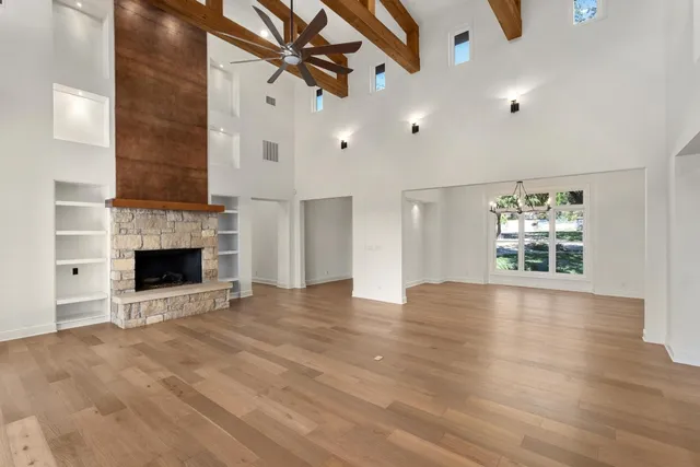 an empty room with windows and a fireplace