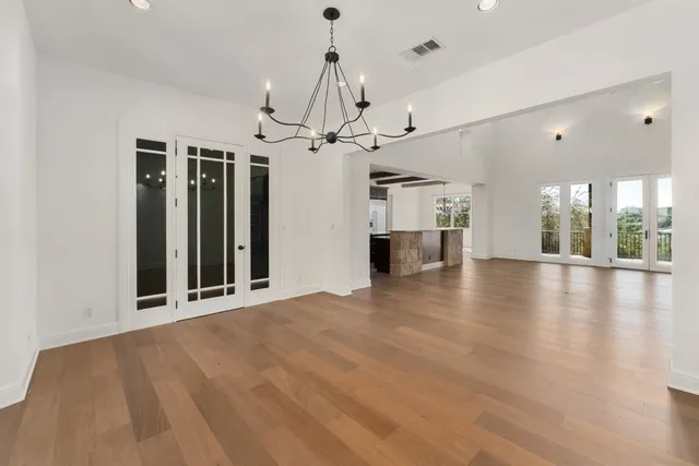 a view of a room with wooden floor fireplace and windows