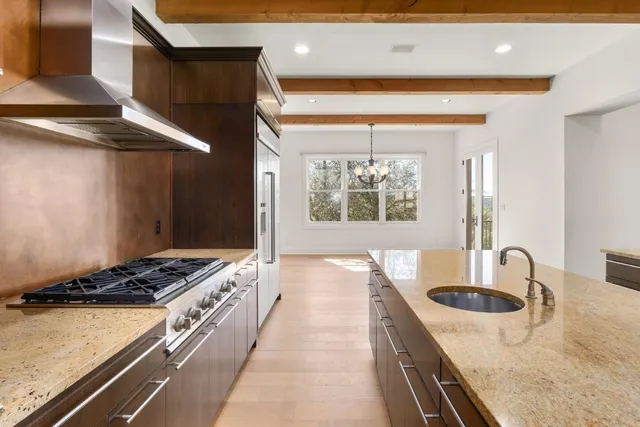 a kitchen with stainless steel appliances granite countertop a stove a sink and a refrigerator