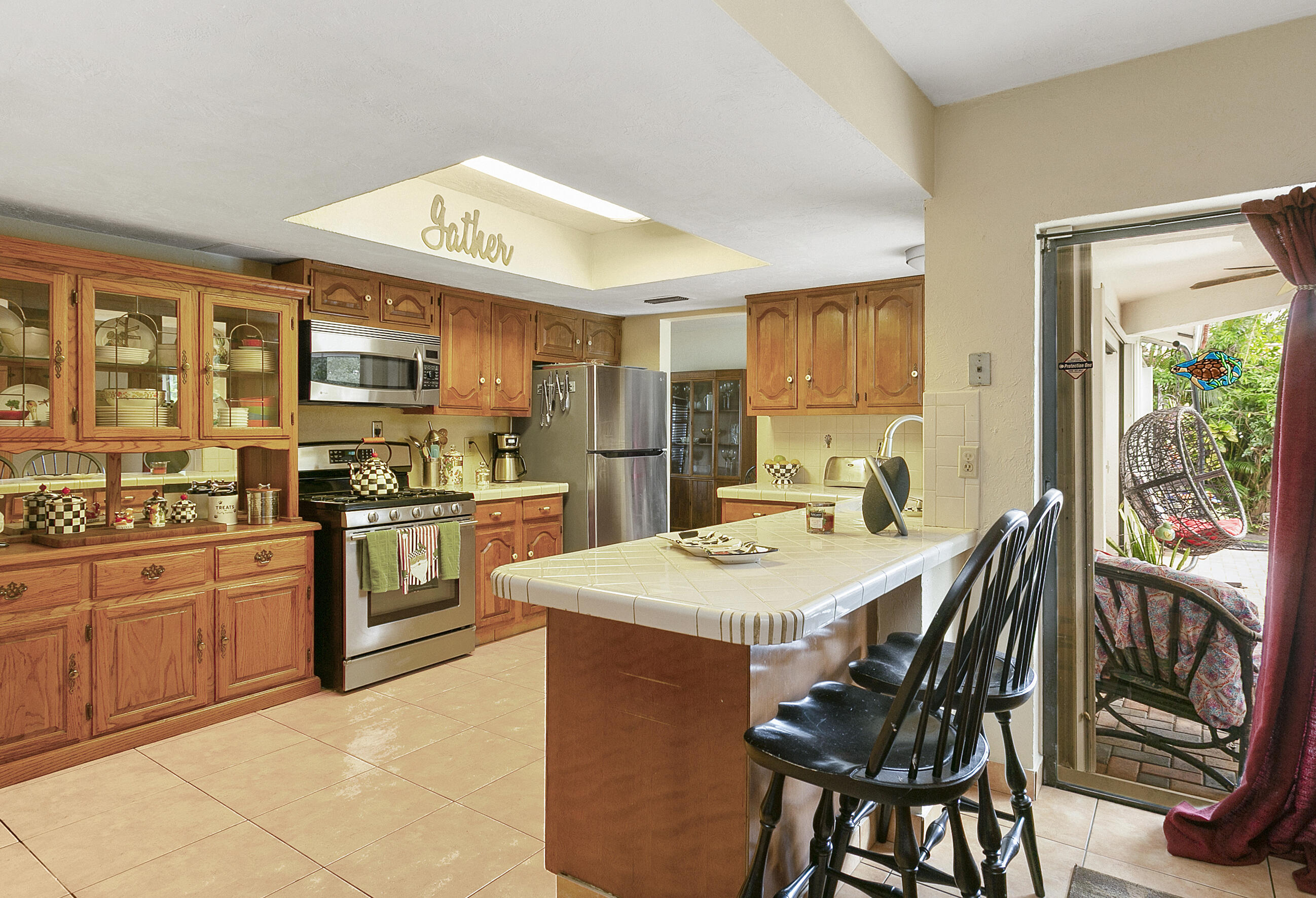 784 Northwest 7th Street Boca Raton, FL 33486 - Photo 5 of 11 a kitchen with stainless steel appliances granite countertop a stove top oven a sink a refrigerator with a dining table and chairs