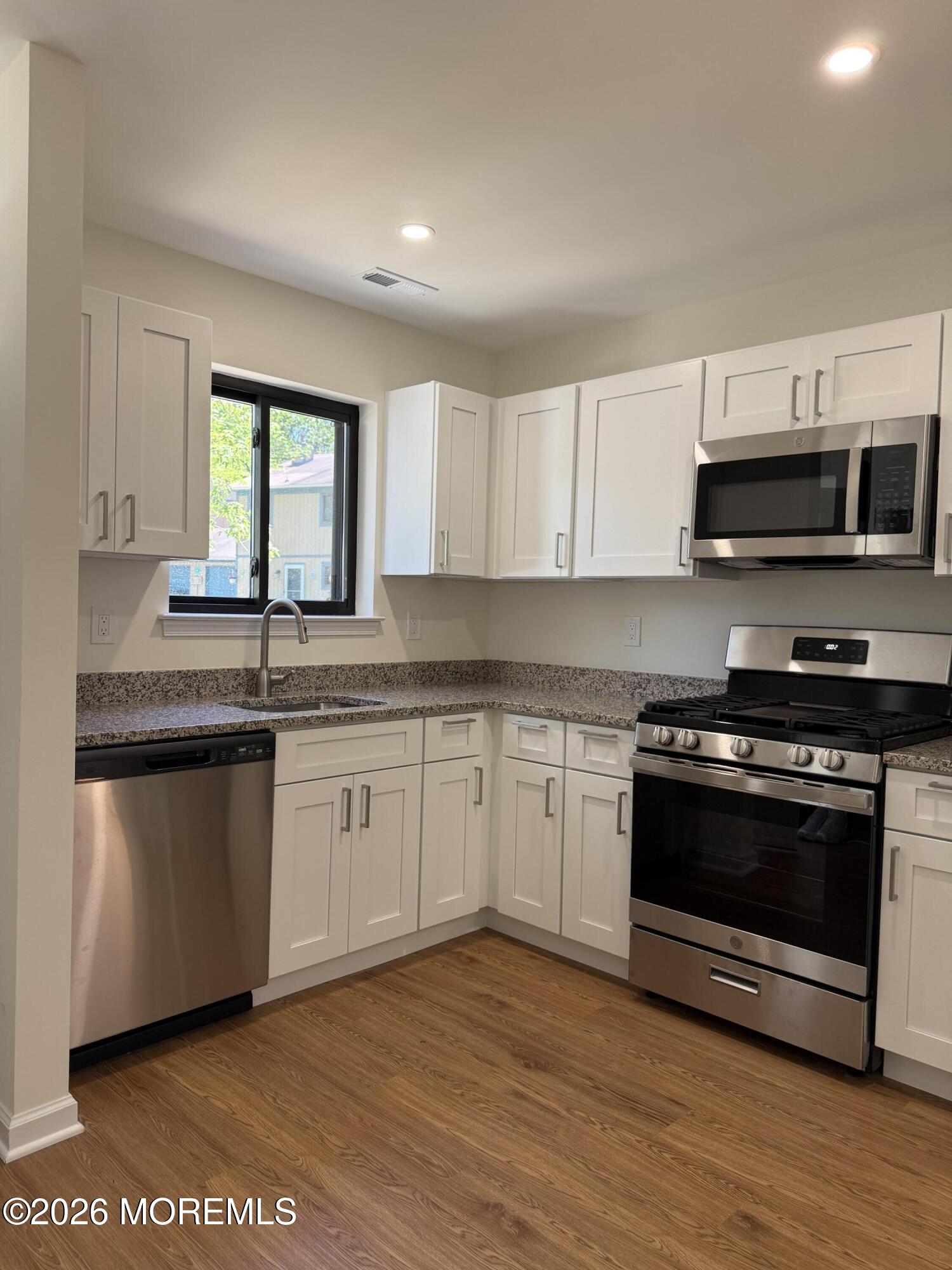 5 Canary Circle Howell, NJ 07731 - Photo 4 of 32 a kitchen with stainless steel appliances granite countertop a stove a sink and a microwave