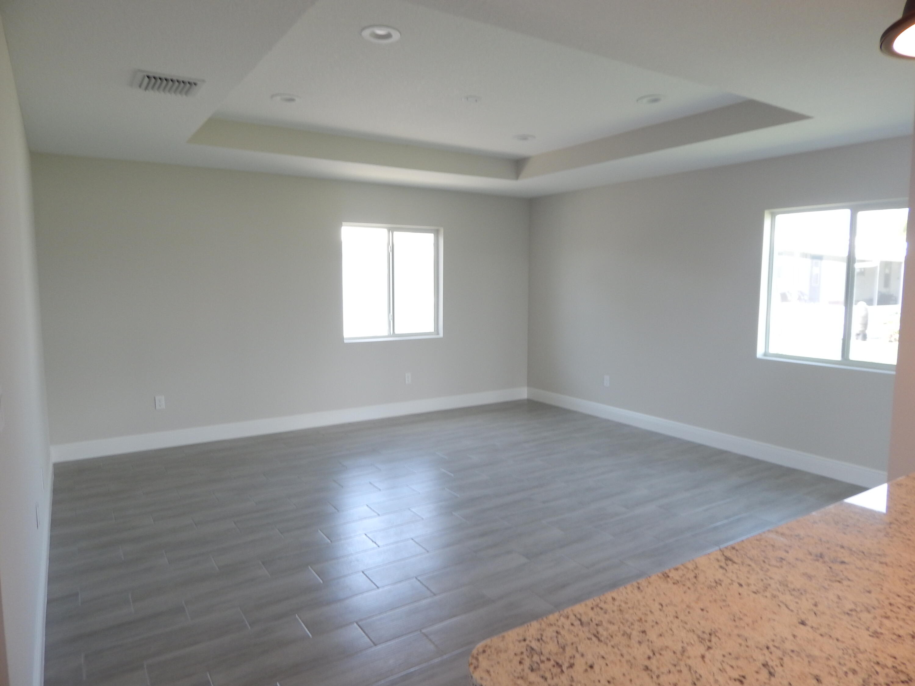 4335 Southwest 15th Way Okeechobee, FL 34974 - Photo 4 of 14 an empty room with wooden floor and windows