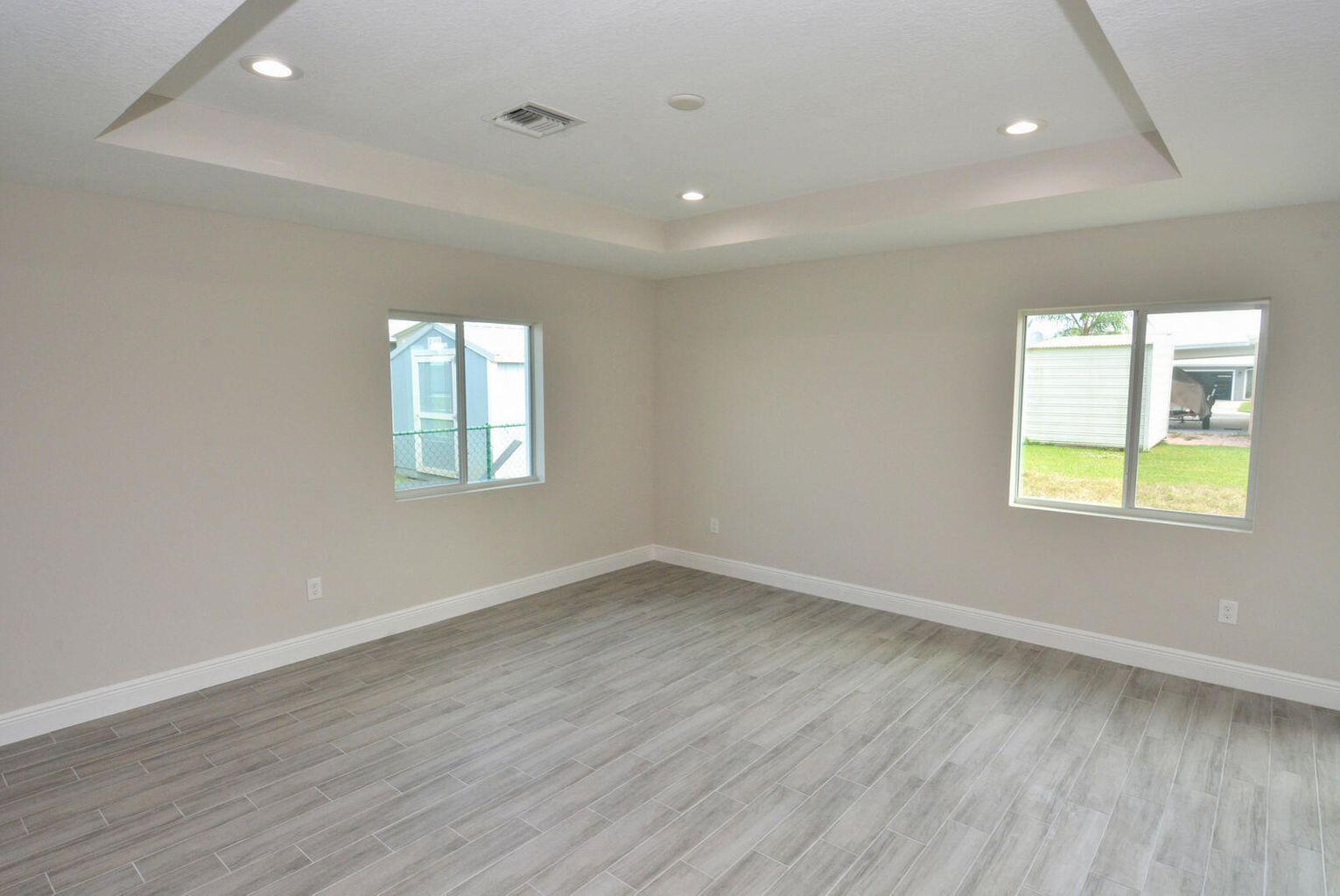 4335 Southwest 15th Way Okeechobee, FL 34974 - Photo 5 of 14 an empty room with wooden floor and windows