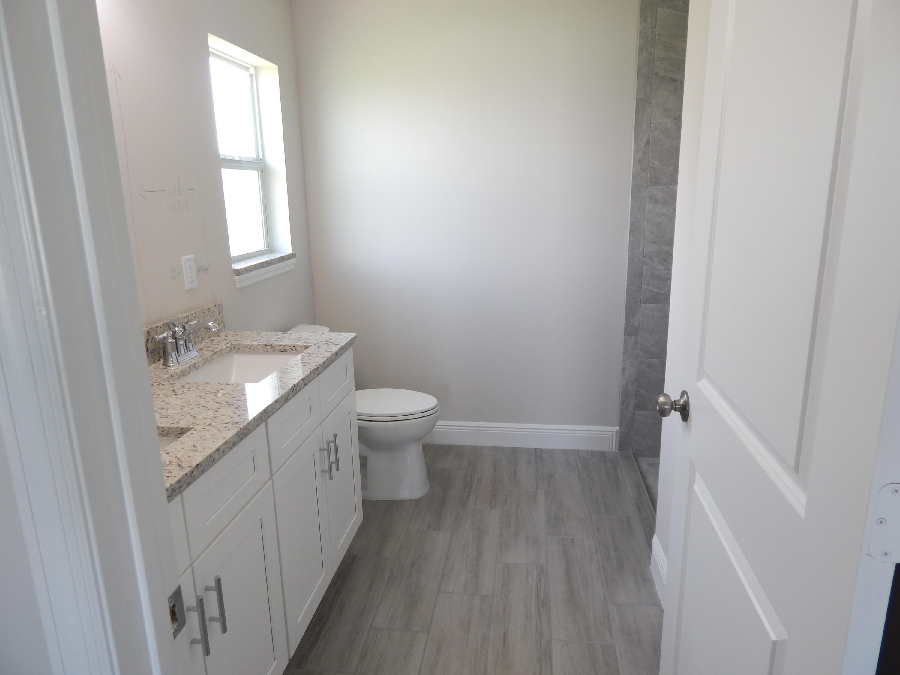 4335 Southwest 15th Way Okeechobee, FL 34974 - Photo 7 of 14 a bathroom with a sink a toilet and tub