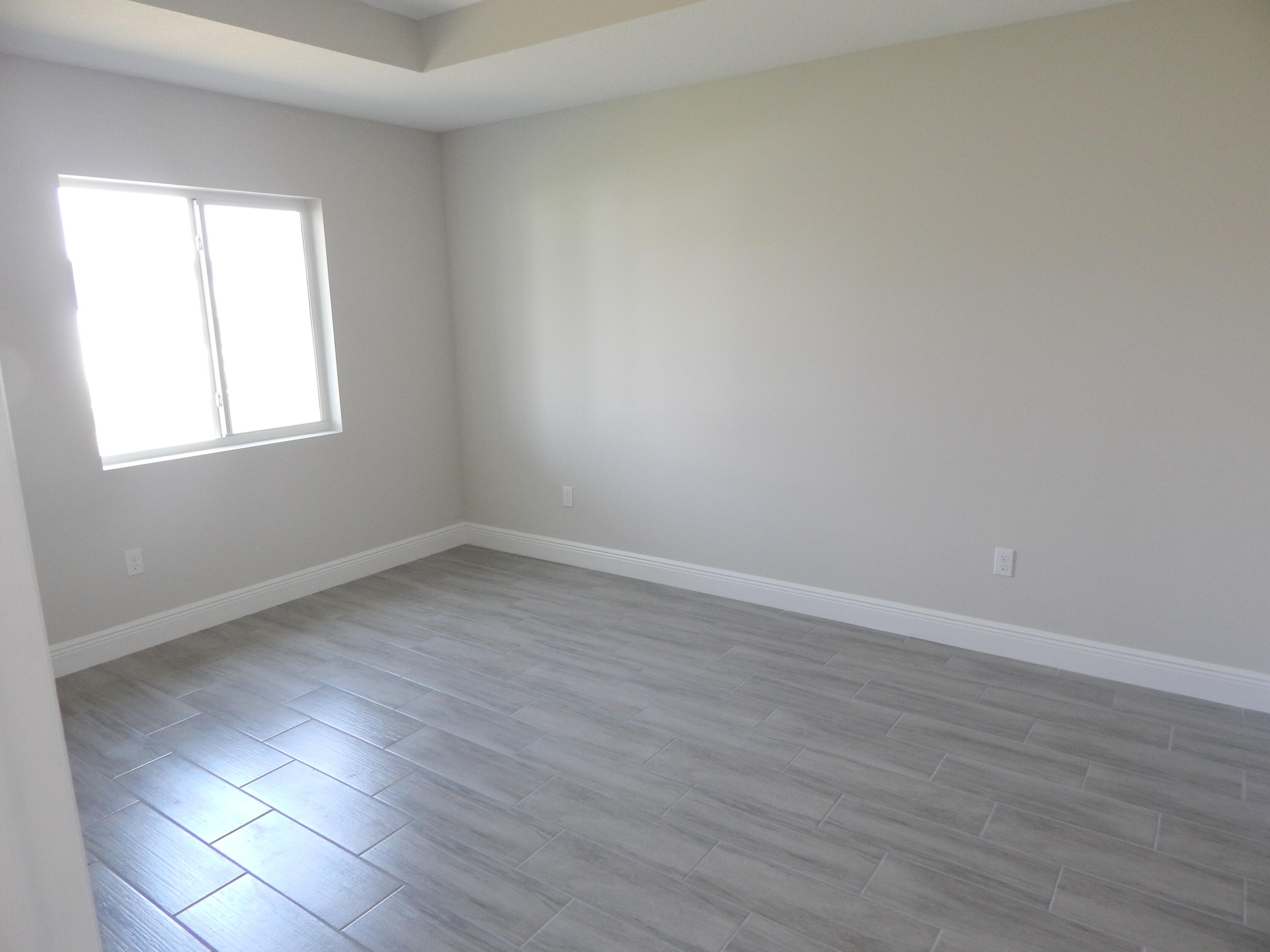 4335 Southwest 15th Way Okeechobee, FL 34974 - Photo 8 of 14 an empty room with wooden floor and windows