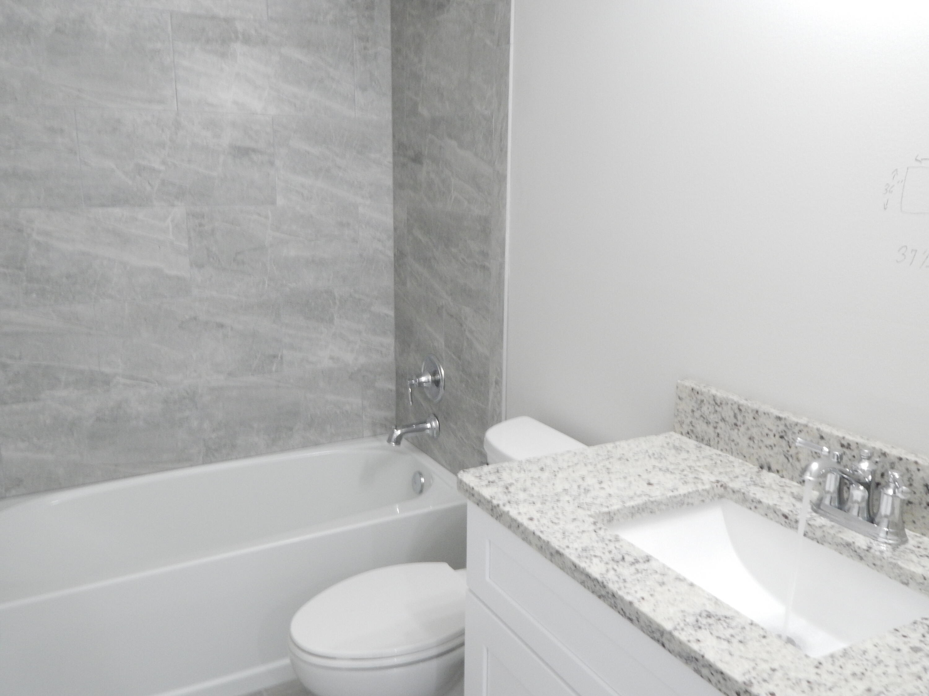 4335 Southwest 15th Way Okeechobee, FL 34974 - Photo 9 of 14 a bathroom with a granite countertop bathtub shower sink vanity and toilet