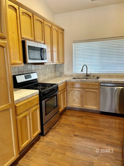 1304 South McCall Street Ridgecrest, CA 93555 - Photo 2 of 22 a kitchen with stainless steel appliances granite countertop a stove a sink and a microwave