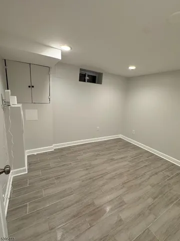 a view of a room with wooden floors and white walls