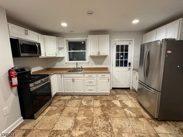 a kitchen with granite countertop a refrigerator stove and microwave