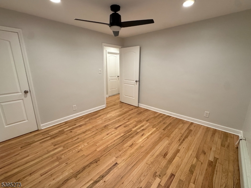 2 Woodside Avenue, Unit 1 Little Falls, NJ 07424 - Photo 6 of 13 an empty room with wooden floor fan and windows