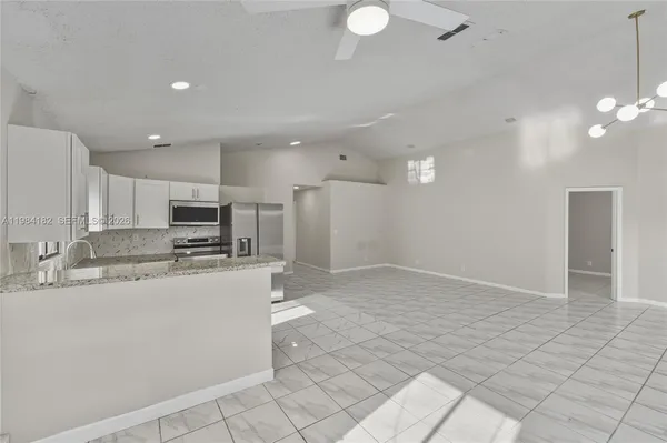 a kitchen with stainless steel appliances a refrigerator sink and microwave