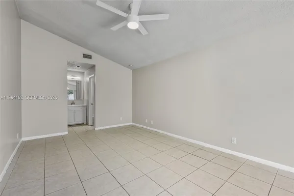 an empty room with fan and entrance