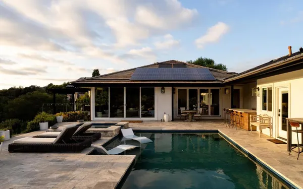 a view of a house with swimming pool and sitting area
