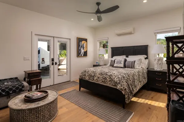 a bedroom with a bed and wooden floor