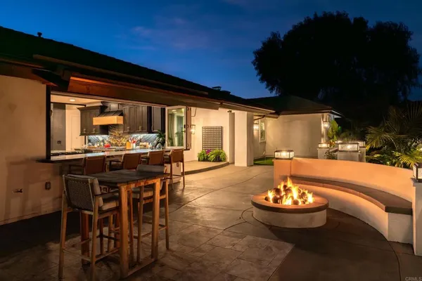 a outdoor dining space with a table and chairs