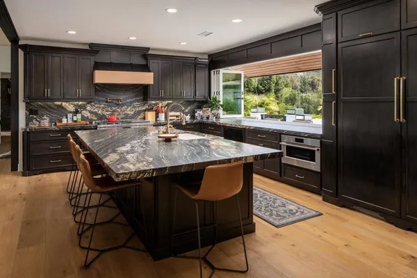 a kitchen with stainless steel appliances granite countertop a stove a refrigerator and a sink