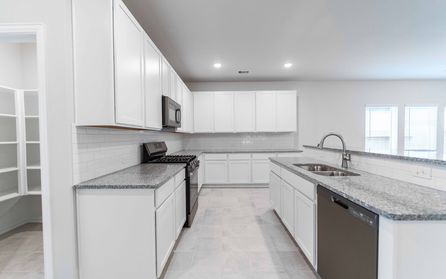 22222 Rome Breeze Drive Hockley, TX 77447 - Photo 8 of 16 a kitchen with stainless steel appliances granite countertop a sink stove and cabinets