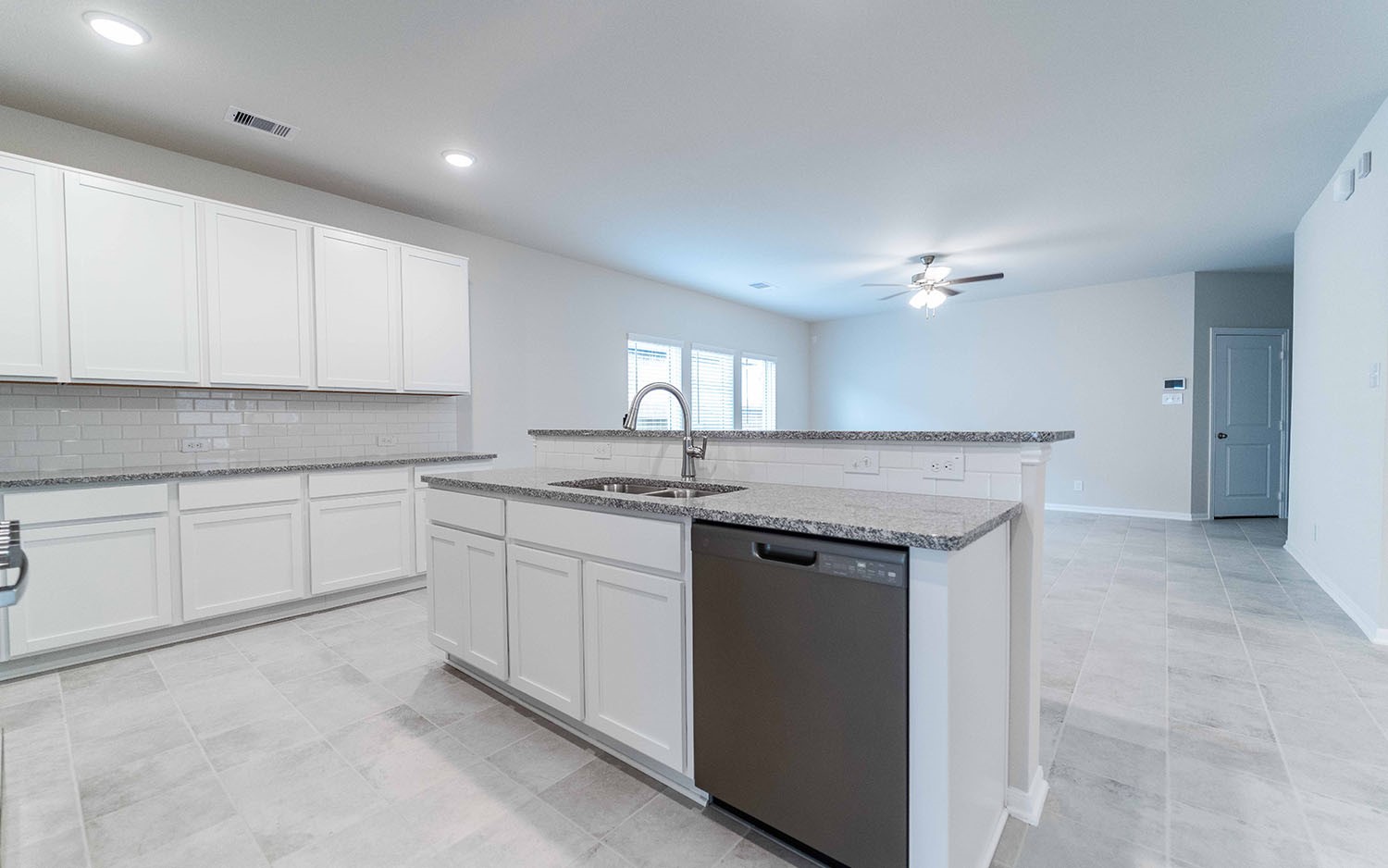 22222 Rome Breeze Drive Hockley, TX 77447 - Photo 9 of 16 a kitchen with granite countertop a sink and white cabinets