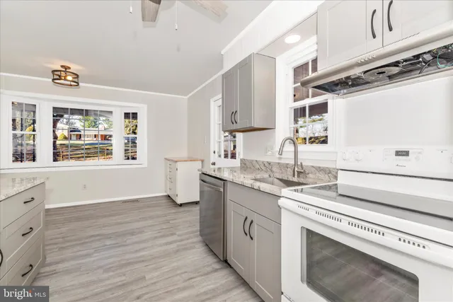 a kitchen with granite countertop a stove and cabinets