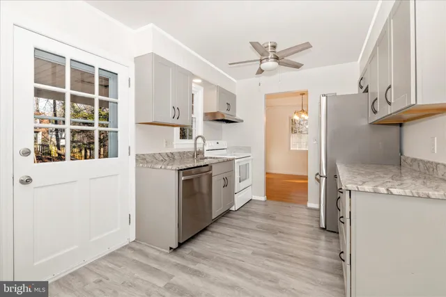 a kitchen with stainless steel appliances granite countertop a stove a sink and a refrigerator