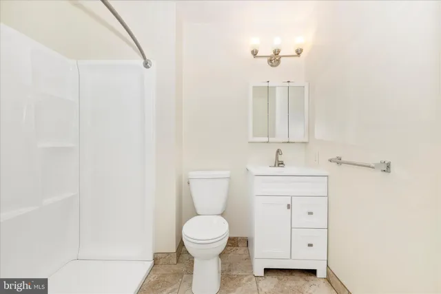 a bathroom with a toilet a sink a mirror and a window