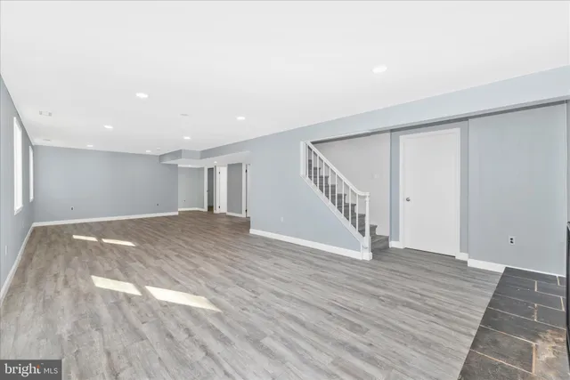 a view of an empty room with wooden floor and entryway