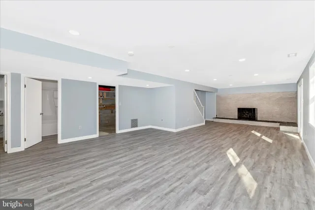 a view of empty room with wooden floor and window