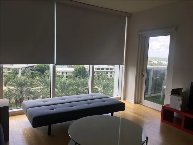 a room with a bed and large windows