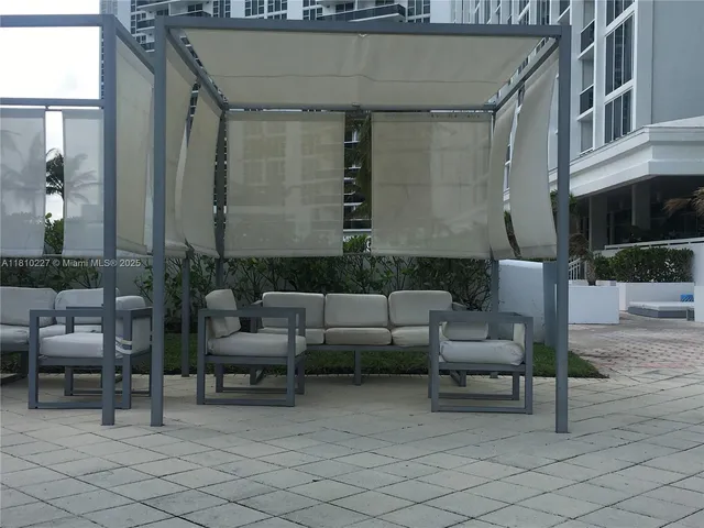 a view of a patio with couches and a potted plant on a table and chairs