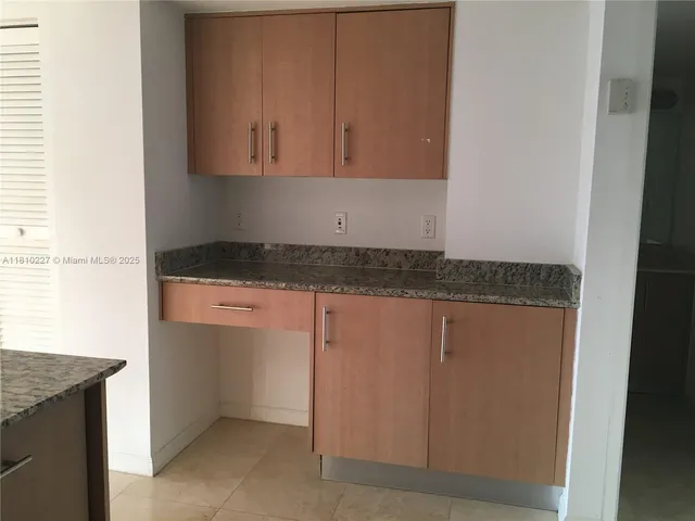 a kitchen with granite countertop cabinets and utility