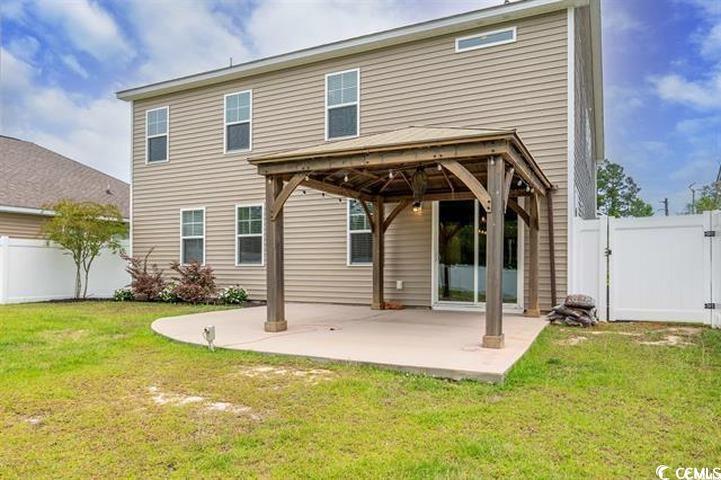 1221 Wind Swept Court Little River, SC 29566 - Photo 19 of 29 Rear view of house featuring a patio and a lawn