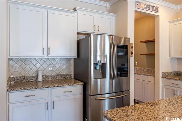 1221 Wind Swept Court Little River, SC 29566 - Photo 4 of 29 Kitchen with light stone counters, white cabinets,