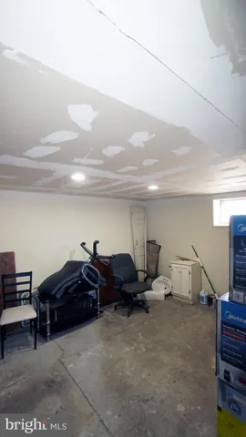 a living room with furniture a flat screen tv and gym equipment