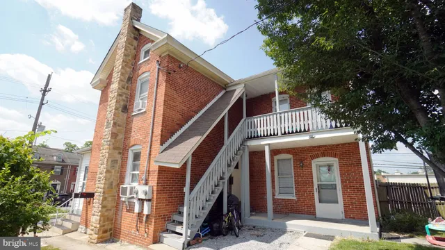 a front view of a house with a tree
