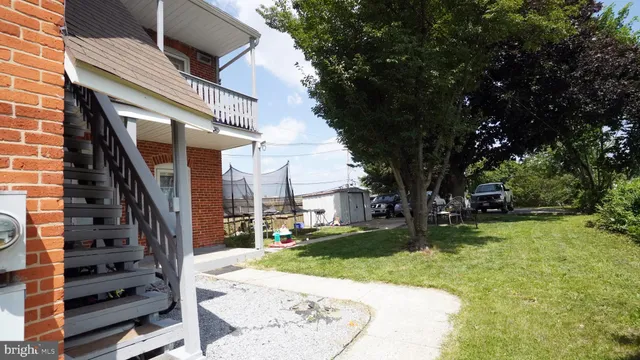 a view of a yard in front of a house with a large tree