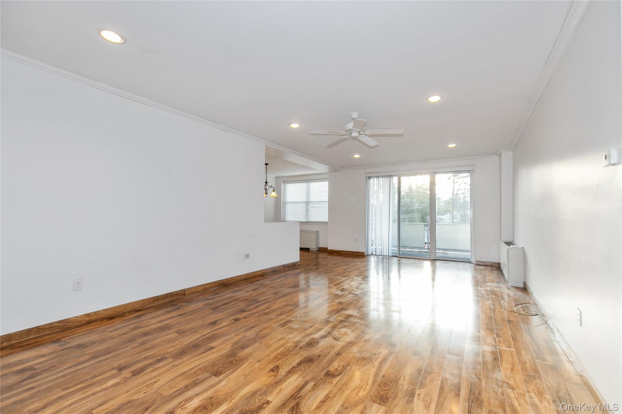 1 Kensington Gate, Unit 302 Great Neck, NY 11021 - Photo 11 of 30 an empty room with wooden floor and windows