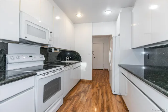 a kitchen with granite countertop a sink and a stove top oven