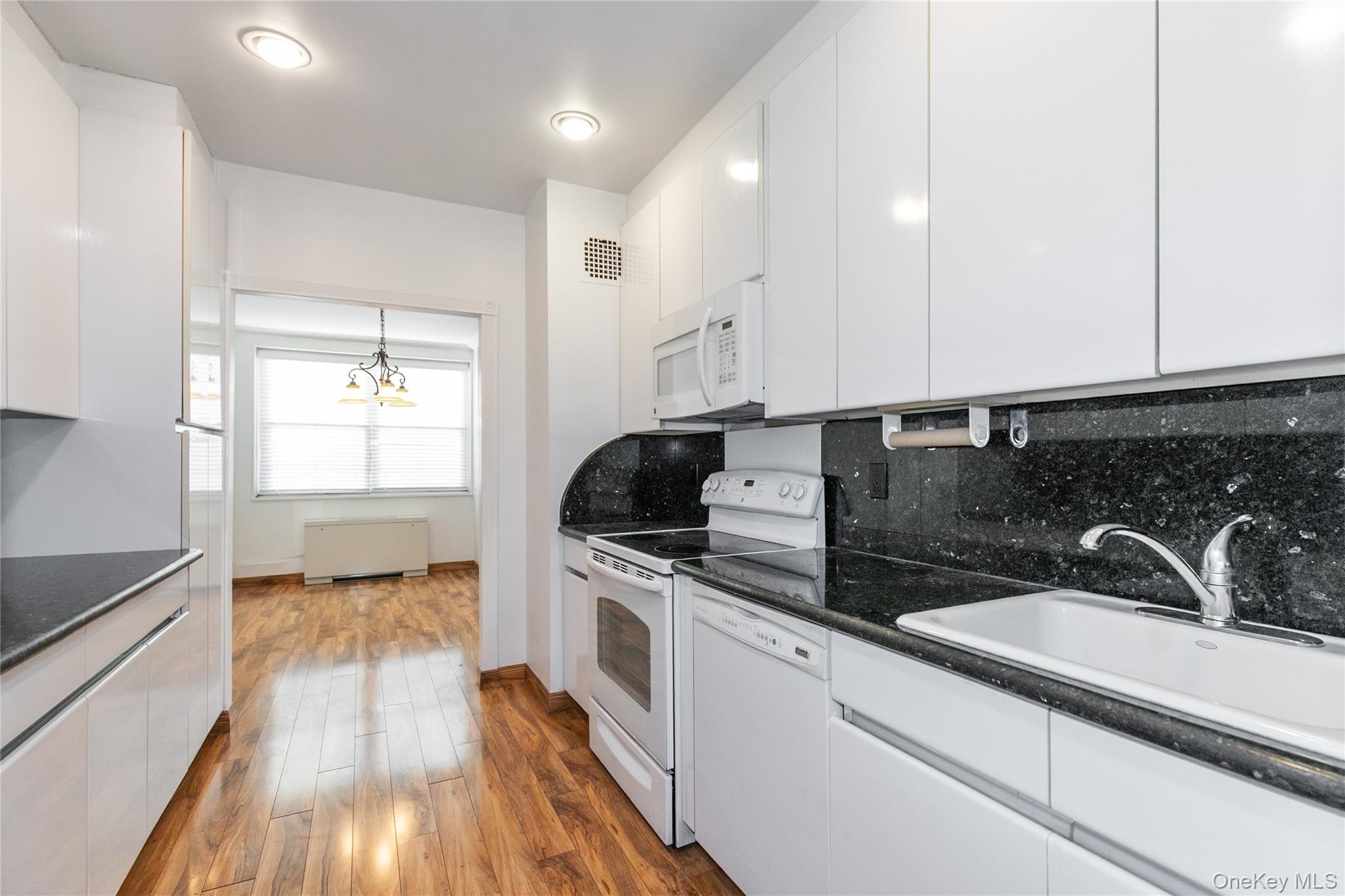 1 Kensington Gate, Unit 302 Great Neck, NY 11021 - Photo 15 of 30 a kitchen with sink a stove and cabinets