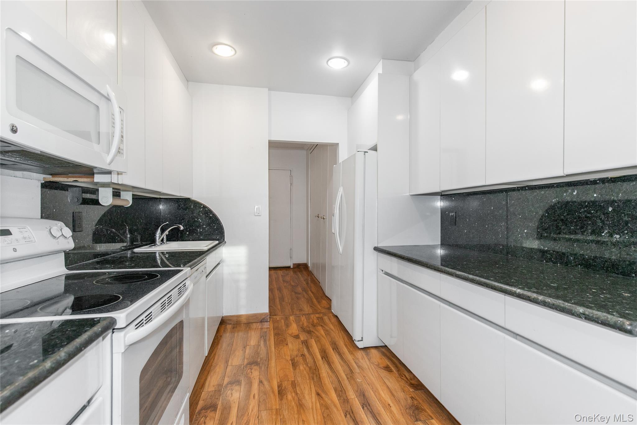 1 Kensington Gate, Unit 302 Great Neck, NY 11021 - Photo 17 of 30 a kitchen that has a sink and a stove