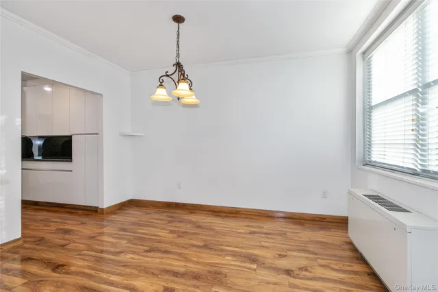 a view of a room with wooden floor and a window