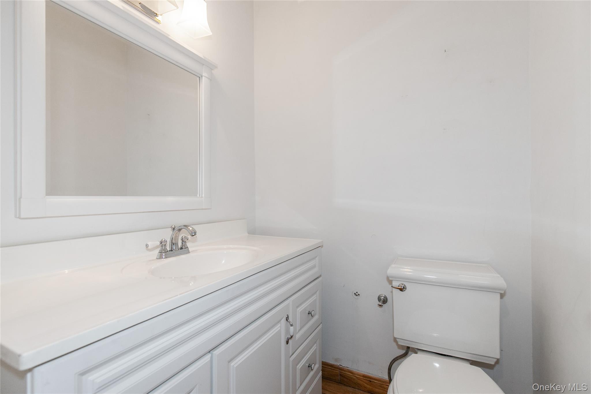 1 Kensington Gate, Unit 302 Great Neck, NY 11021 - Photo 19 of 30 a bathroom with a sink mirror and toilet