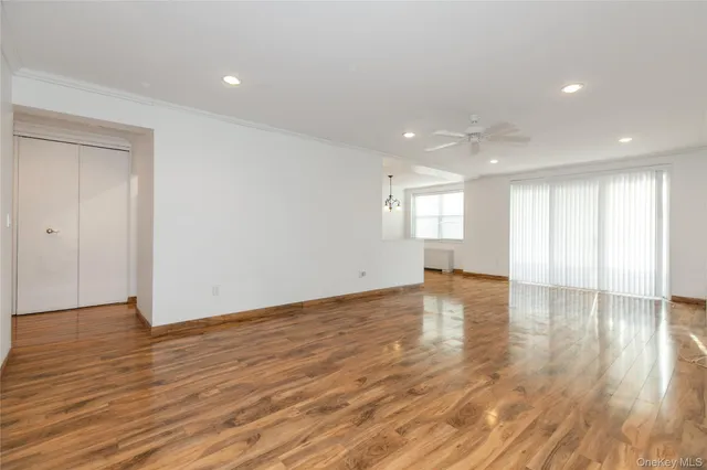 a view of empty room with wooden floor and window