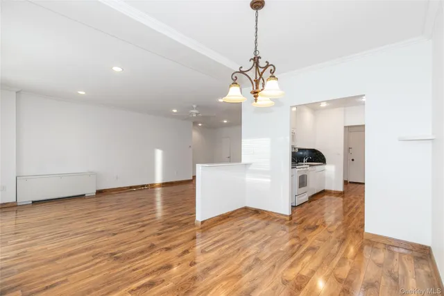 a view of a kitchen with a sink stainless steel appliances and a chandelier