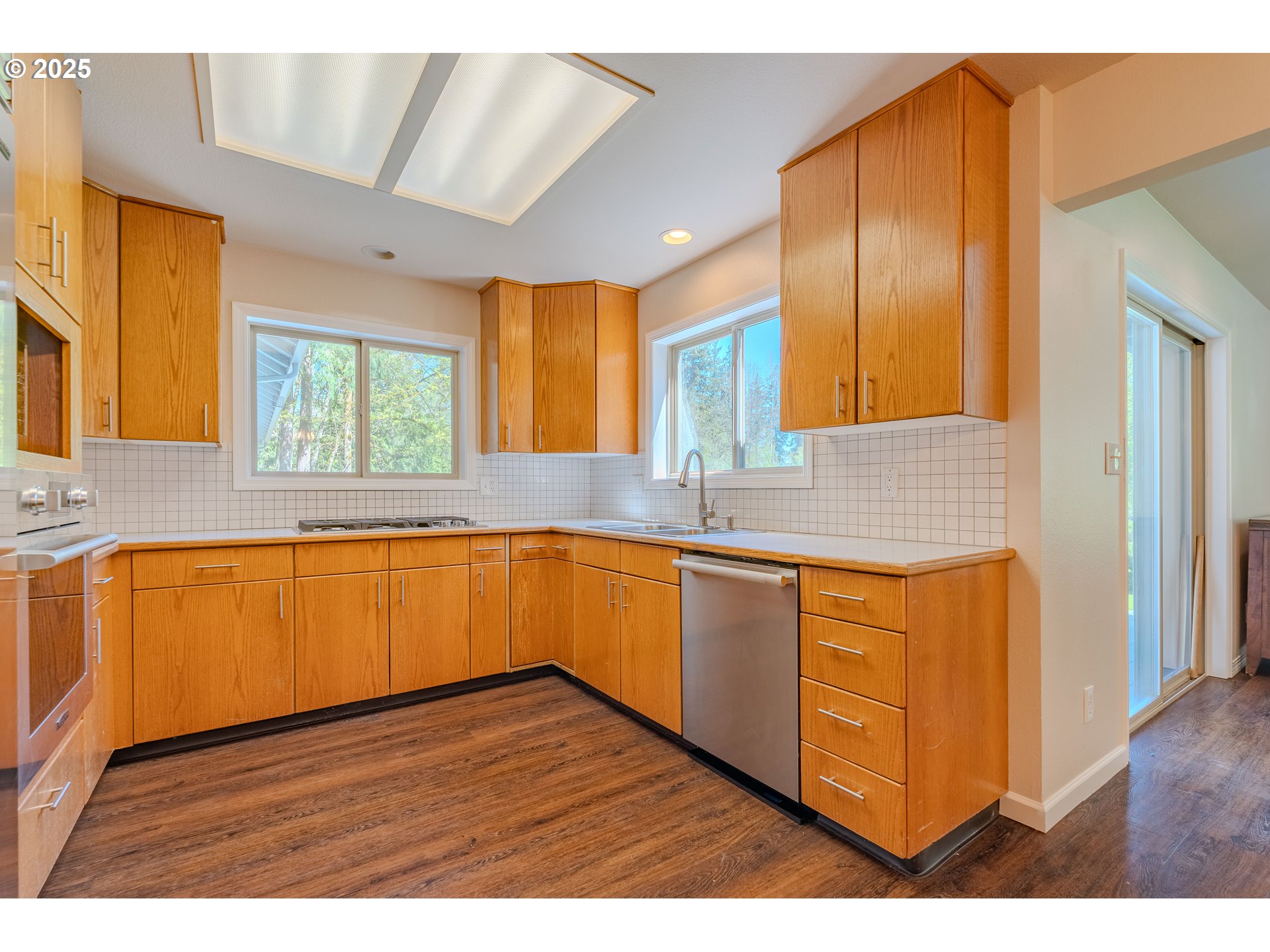 2126 Northeast 194th Street Ridgefield, WA 98642 - Photo 14 of 44 a kitchen with stainless steel appliances granite countertop wooden cabinets a sink and dishwasher with wooden floor