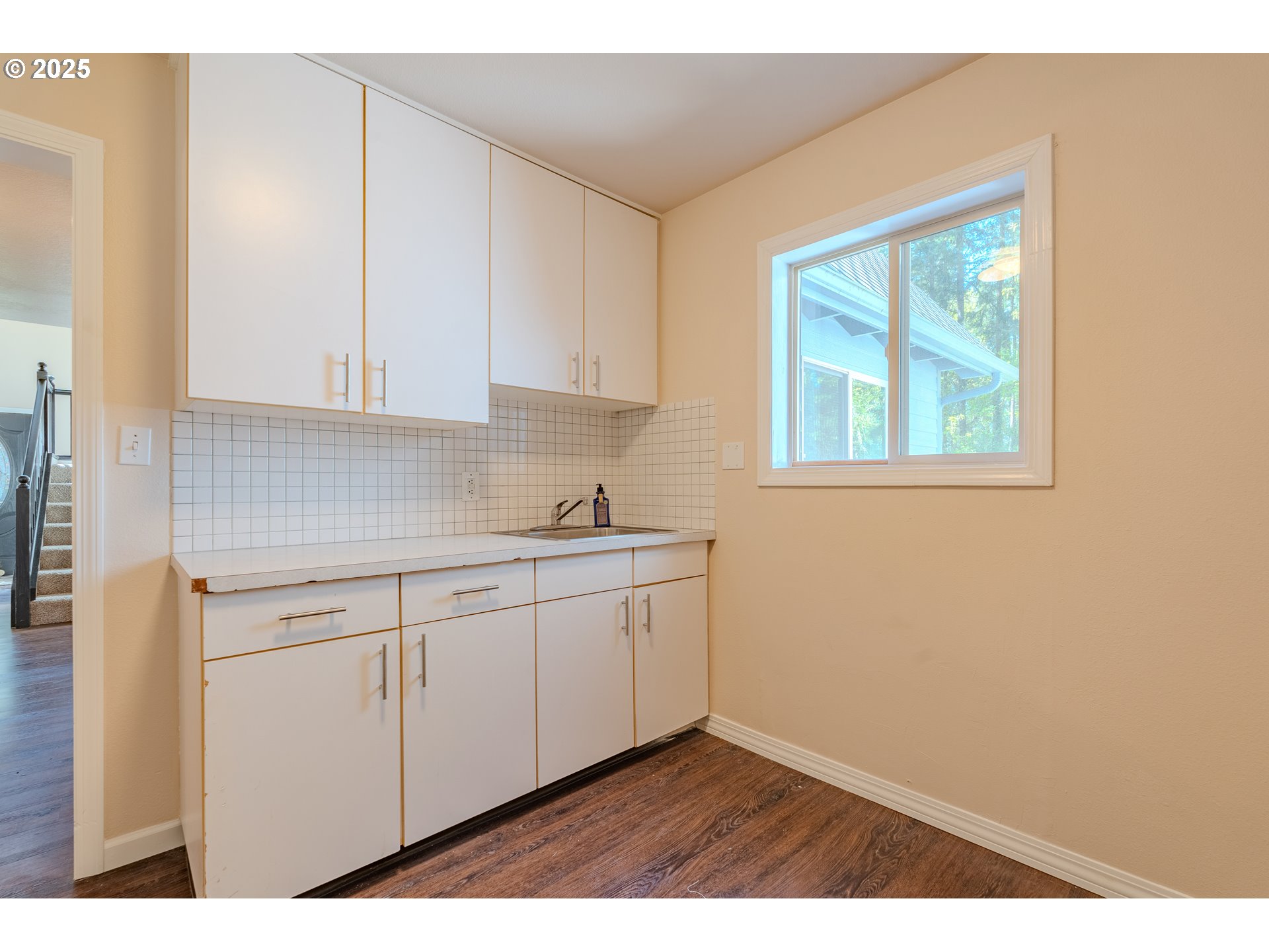 2126 Northeast 194th Street Ridgefield, WA 98642 - Photo 19 of 44 a kitchen with granite countertop white cabinets a sink a window and a wooden floor
